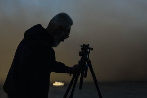 Aftermath - Ron Grogan takes down his camera and tripod as the cloud of dust rolls in.  Copyright 2015. Photo by Grace Grogan